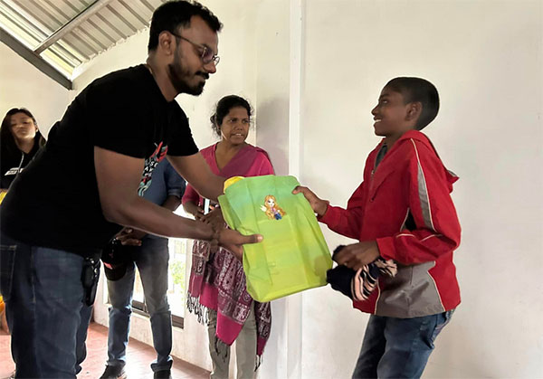 Distributing exercise books to the children